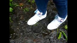 Jana walks with her Adidas Top Ten white patent with loop through the mud yt trailer